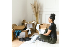 Image Woman sifting through her clothes and choosing what to keep donate or throw away.